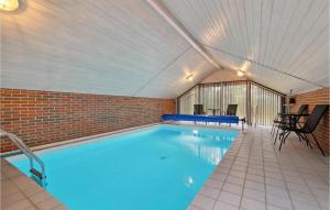 维斯特索马肯Lovely Home In Aakirkeby With Kitchen的一座带砖墙的大型游泳池