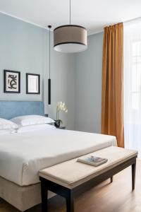 佛罗伦萨Flom Boutique Hotel的卧室配有一张白色的大床和一张桌子