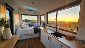 KillarneyCoastal Sunset Tiny Home - Port Fairy Tiny Homes的一间卧室设有一张床和一个大窗户