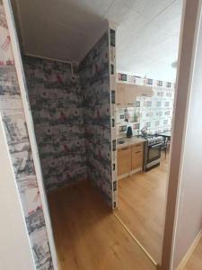 萨拉斯皮尔斯Salaspils Apartament 2023的厨房设有走廊,墙上贴有壁纸