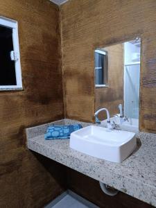 布希奥斯Pousada Alto da Marina的浴室设有白色水槽和镜子