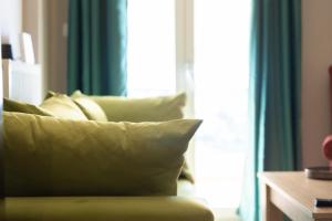 拉里萨GPX-CLR TheGreenFamilySuite的窗户前带枕头的绿色沙发