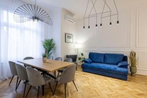 布达佩斯Luxurious Central 4BEDRM 3BATHRM Residence w/ Balcony的客厅配有蓝色的沙发和桌子