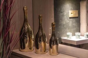 列日SuiteDreams - Bali Suite Liège的藏在架子上的三瓶葡萄酒