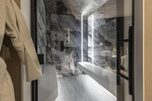 列日SuiteDreams - Bali Suite Liège的一间带水槽和石墙的浴室