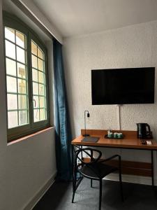 佩皮尼昂小屋酒店的一张桌子,电视机和椅子放在房间里