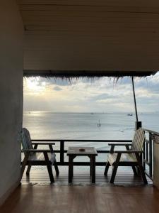 哈林海滩阳光崖度假酒店的俯瞰大海的阳台配有两把椅子和一张桌子
