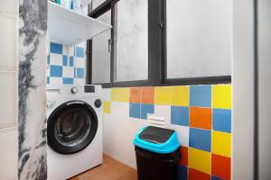 卡尔达斯达·赖尼亚Apartamento da Alegria的浴室里设有一台洗衣机,墙壁色彩缤纷