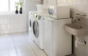 OvezandeNice Home In Ovezande With Wifi的白色洗衣房配有洗衣机和烘干机