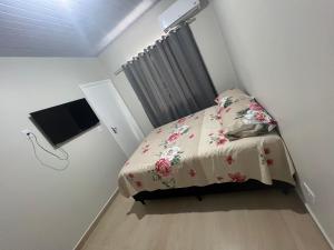 伊瓜苏Boicy Residence的一间小卧室,配有一张床和一台平面电视