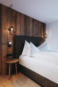 莱赫阿尔贝格Balma Restaurant Apart的卧室配有白色的床和木墙