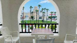 苏塞Bungalow S+1 à Kantaoui, Sousse, avec Vue Panoramique Exquise的窗户客房内的桌椅