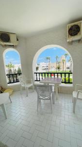 苏塞Bungalow S+1 à Kantaoui, Sousse, avec Vue Panoramique Exquise的客房设有2扇窗户和桌椅。
