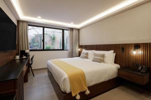 瓜达拉哈拉Origen 438 Luxury Boutique Hotel的一间卧室设有一张大床和一个窗户。