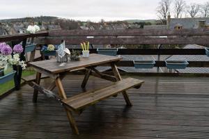 亨特利Dunedin House -Contractors - Business Travellers的甲板上的木餐桌和长凳
