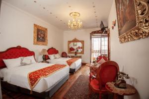 库斯科Casona Corrales Hotel Boutique的一间卧室配有两张床、一把椅子和一个吊灯。