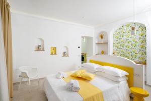 波西塔诺L'Acquolella的白色卧室配有床和椅子