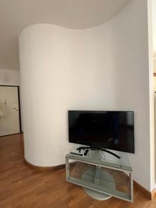 阿尔本加DEA apartment的客厅配有白色墙壁上的平面电视。
