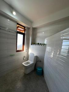 甘托克Morning Mist Homestay的白色的浴室设有卫生间和窗户。