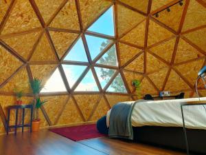 Lodares de OsmaMiradomos Glamping Rural的客房设有床和大窗户。