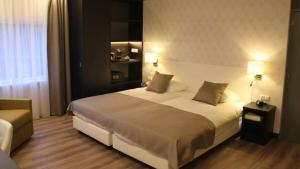埃尔斯特埃尔斯特海特威朋酒店的一间卧室配有一张带两盏灯的大型白色床。