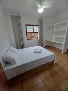乌巴图巴Casa com Jacuzzi aquecida praia do Lazaro的卧室配有白色的床和窗户。