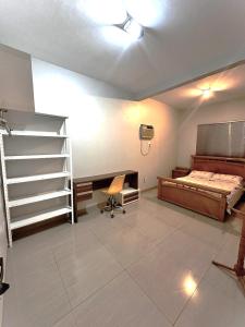 阿拉瓜伊纳Hospedagem aconchegante com área gourmet的一间卧室配有一张床、一张桌子和梯子