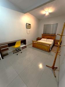 阿拉瓜伊纳Hospedagem aconchegante com área gourmet的一间卧室配有一张床、一张桌子和一把椅子