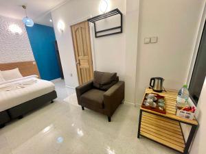 马米基里考马拉旅馆的一间卧室配有一张床、一把椅子和一张桌子