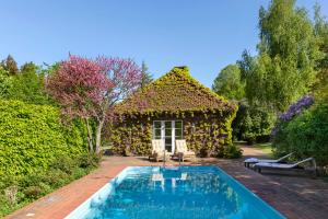 HarmsdorfGut Einhaus an der Ostsee - Großzügiges Haus mit Tennisplatz und Pool sowie Garten und Ostseenähe的庭院中带游泳池的房子