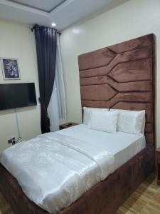 莱基Somek Homes2的一间卧室配有一张大床和木制床头板