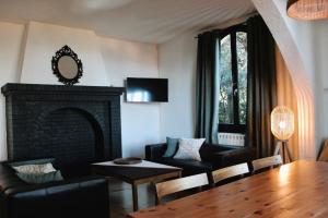耶尔Villa les Grillons的客厅设有壁炉、桌子和椅子