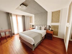 阿雷基帕帆迪朵酒店的卧室配有一张白色的大床和一张桌子