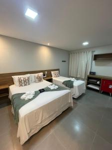 戈亚斯州上帕莱索Villa Tereza的一间卧室配有两张鲜花床。