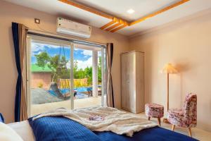 潘奇加尼Malibu Villa by Hill Staytion的一间卧室设有一张床和一个滑动玻璃门
