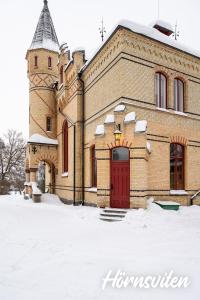 TimråMerlo Slott的一座大砖砌的建筑,雪中有一扇红色的门