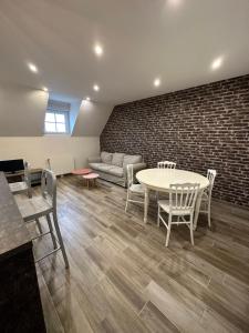 博讷Appartement à Beaune avec Parking的客厅配有桌椅和砖墙