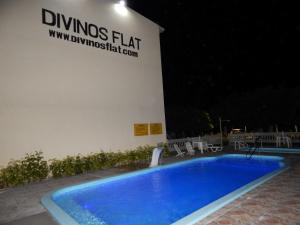 普拉亚多斯卡内罗斯Divinos Flat Carneiros的一座游泳池,在晚上在建筑物前