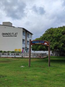 普拉亚多斯卡内罗斯Divinos Flat Carneiros的建筑物前草上的标志