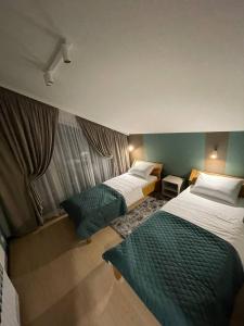 亚布卢尼齐亚Horizon Apartmens的一间酒店客房,房间内设有两张床