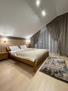亚布卢尼齐亚Horizon Apartmens的一间卧室配有一张大床和地毯。