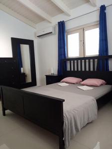 克拉伦代克Caribbean Court E1的一间卧室配有一张带粉红色枕头和镜子的床