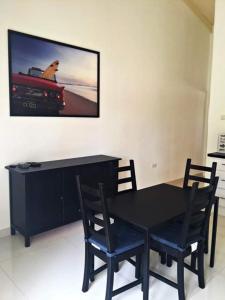克拉伦代克Caribbean Court E1的一张黑色餐桌、两把椅子和电视