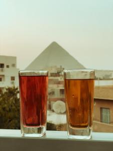 开罗hermanos pyramids view的两杯啤酒坐在一个金字塔的顶端
