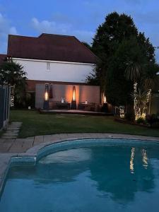 莫尔西Hampton Oasis with Heated Pool & Large Garden的房屋前的游泳池