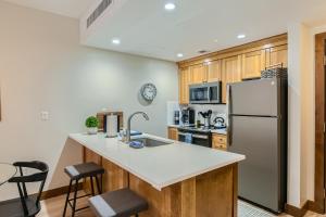 帕克城Sundial Apartment B217的厨房配有不锈钢冰箱和木制橱柜