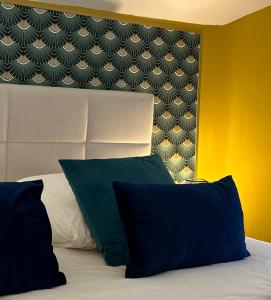 迈松拉菲特Appart' Studio cooconing - Champs Elysées - JO 2024的一间卧室配有带两个枕头和床头板的床