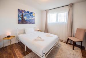 耶洛奈夫Yellowknife Downtown Toboggan Hill Retreat的卧室配有白色的床和椅子