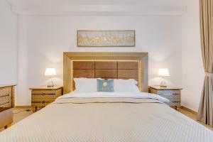 迪拜GLOBALSTAY. Luxury 3 Bedroom + Maid Townhouse with Sea View的一间卧室配有一张带两盏灯的大型白色床。