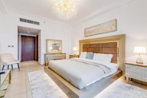 迪拜GLOBALSTAY. Luxury 3 Bedroom + Maid Townhouse with Sea View的一间卧室配有一张大床和一个吊灯。